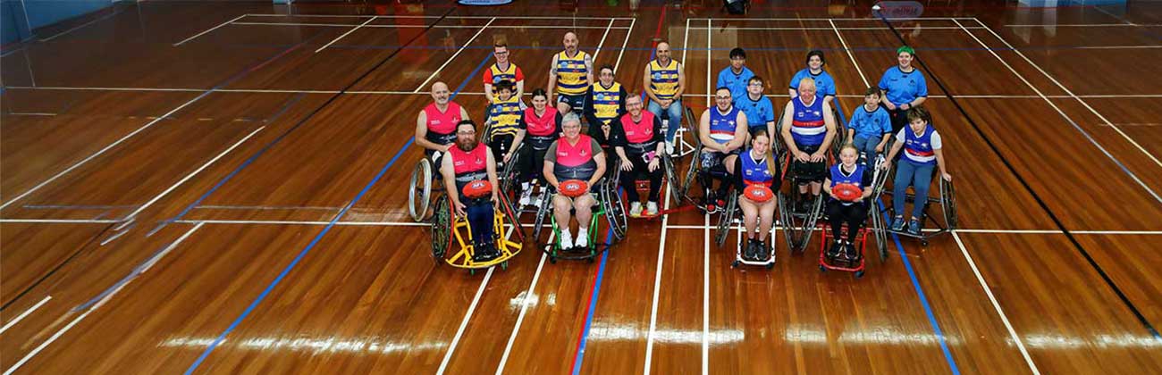 A group of wheelchair football participants on the indoor court